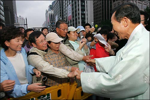 지난 2005년 10월 1일 당시 이명박 서울시장이 청계천 새물맞이 행사에 참석한 시민들과 악수를 하고 있다.